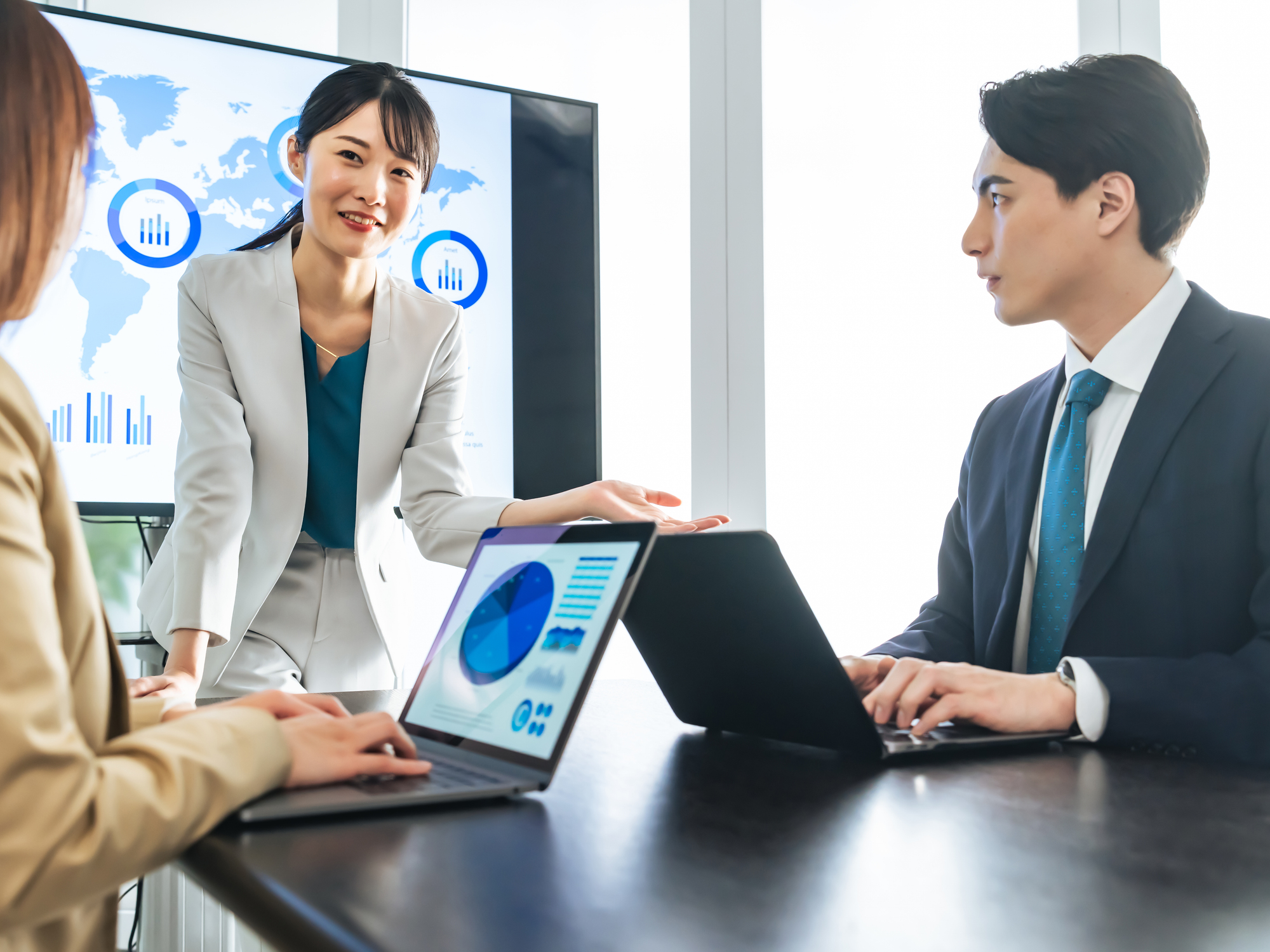 データを確認しながら事業展開を話し合うチームのイメージ